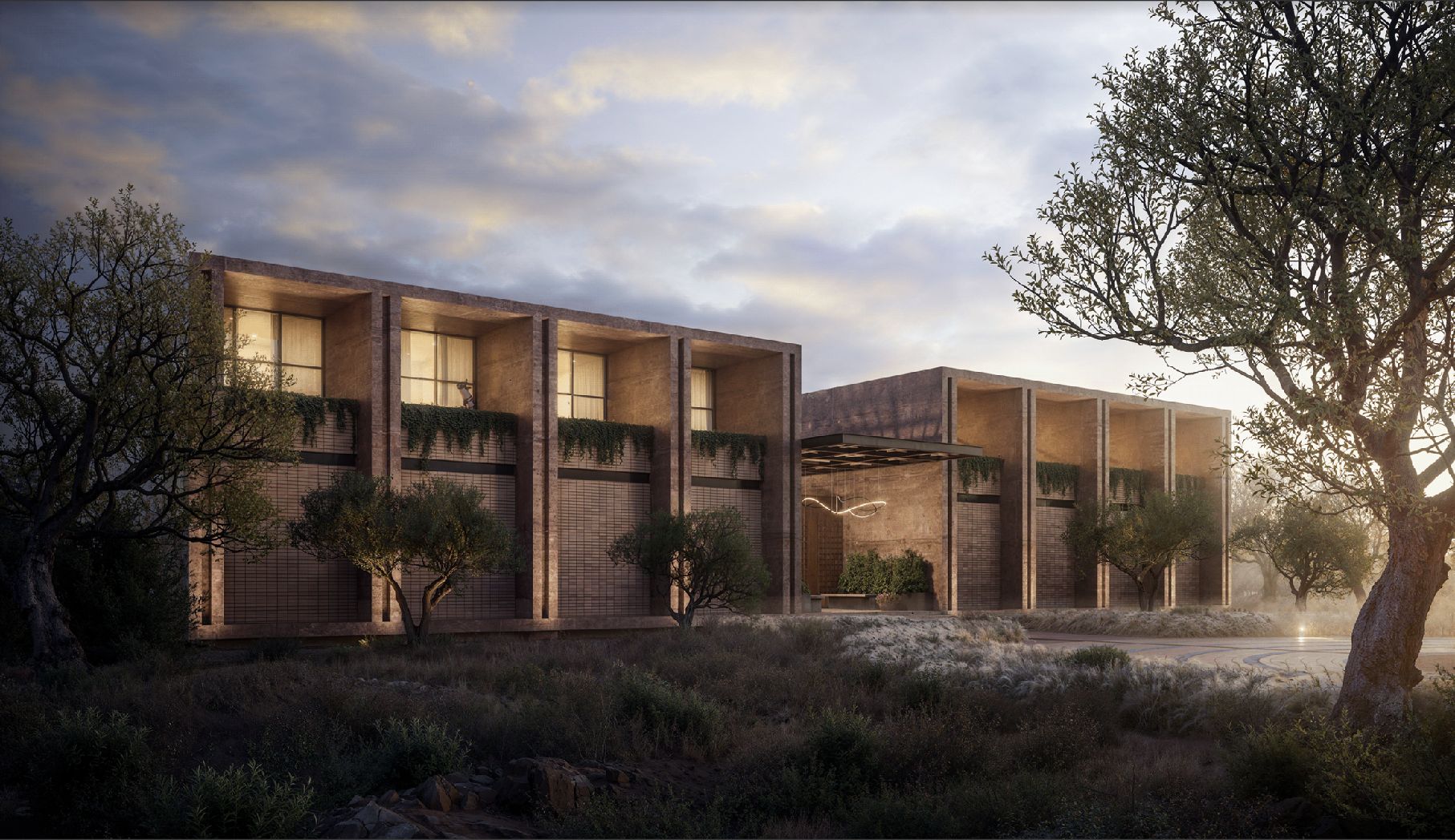 The Spark campus at dusk, warm light glowing from its brick pavilions